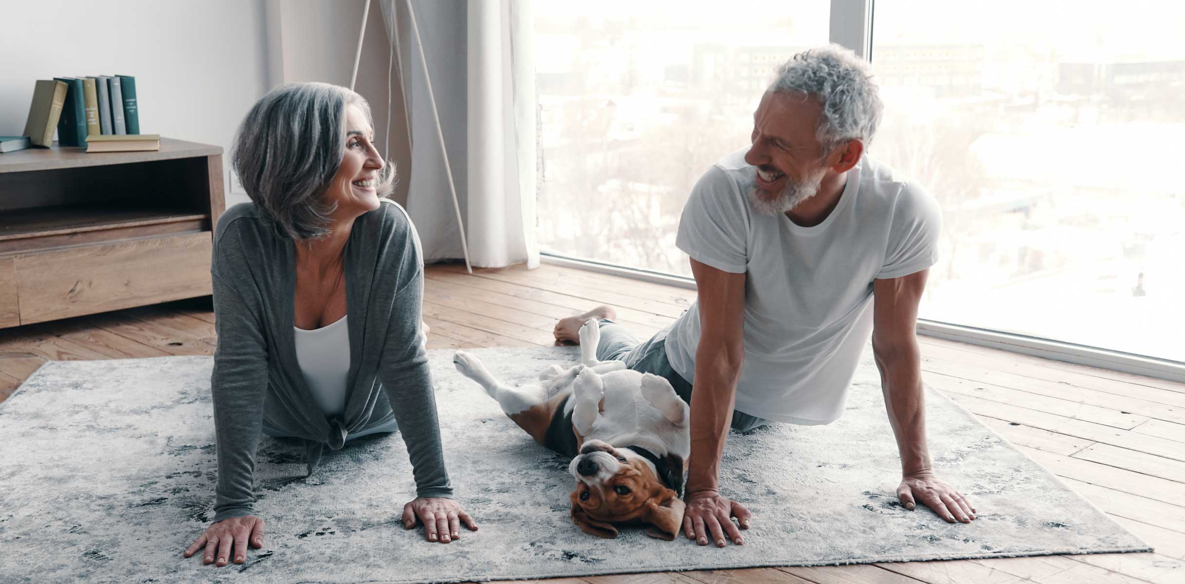 Senior couple doing yoga with their dog
